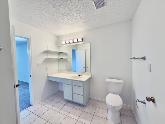 7817 Marble Ridge Dr, Austin, TX 78747 - bathroom featuring a textured ceiling, toilet, vanity, tile patterned floors, and baseboards
