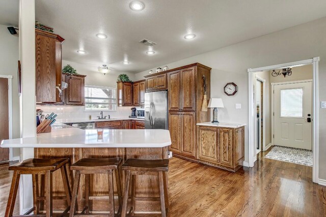 603 Watterson Rd Unit B, Bastrop, TX 78602 - kitchen featuring stainless steel appliances, a peninsula, light wood-style floors, a breakfast bar area, and a sink