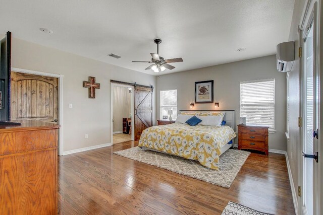 603 Watterson Rd Unit B, Bastrop, TX 78602 - bedroom featuring a barn door, multiple windows, baseboards, and wood finished floors
