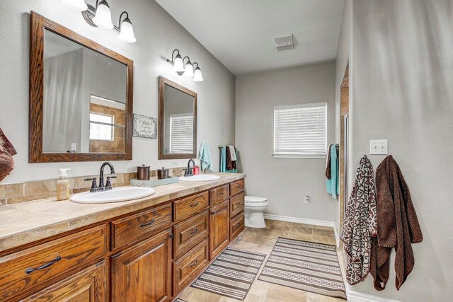 603 Watterson Rd Unit B, Bastrop, TX 78602 - full bath with double vanity, toilet, an enclosed shower, and baseboards