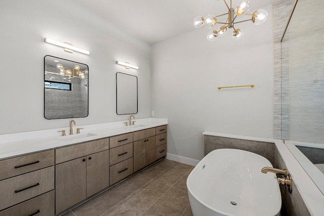 bathroom with a chandelier, double vanity, a soaking tub, and tile patterned flooring