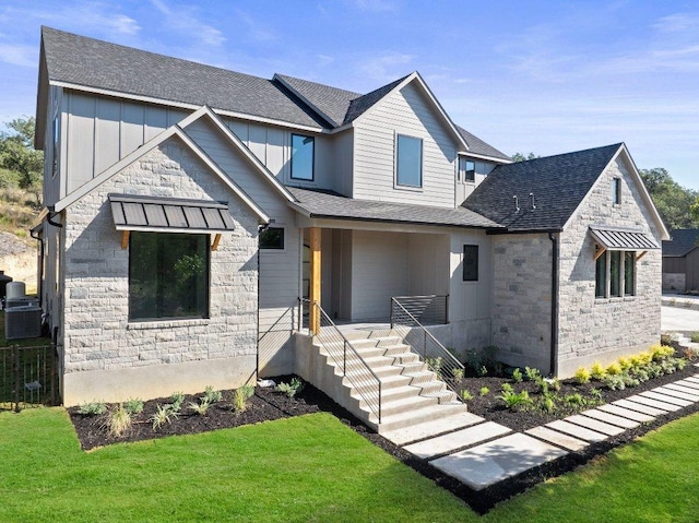 view of front of home featuring stone siding, board and batten siding, and a shingled roof