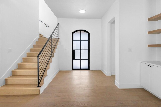19634 Thurman Bend Rd, Spicewood, TX 78669 - entrance foyer with light wood finished floors and stairs
