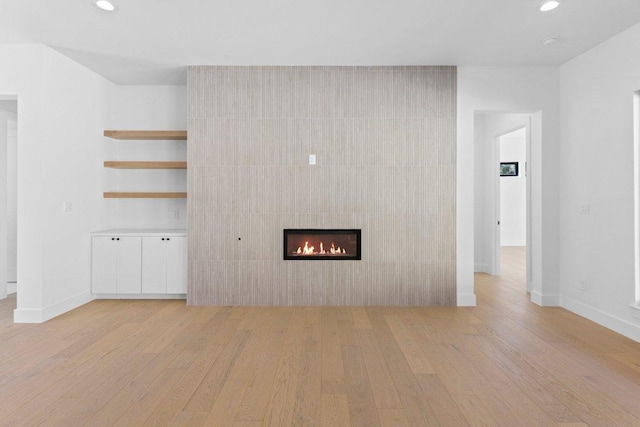 19634 Thurman Bend Rd, Spicewood, TX 78669 - unfurnished living room featuring light wood-style flooring, recessed lighting, and a fireplace