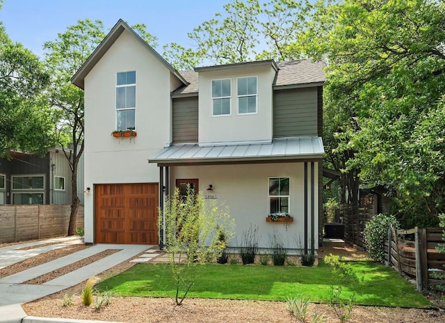 1406 Cometa St Unit 1, Austin, TX 78721 - view of front of house with an attached garage, fence, a standing seam roof, and a shingled roof