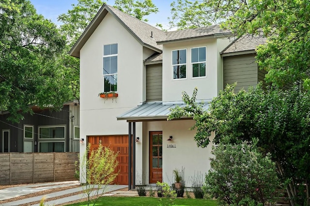 1406 Cometa St Unit 1, Austin, TX 78721 - view of front of home with stucco siding, a garage, roof with shingles, fence, and a standing seam roof