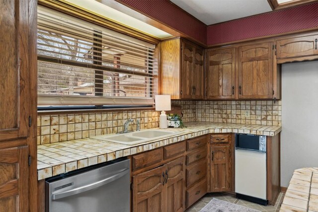 2821 Creek Side Dr, Temple, TX 76502 - kitchen featuring dishwasher, a sink, tile countertops, and decorative backsplash