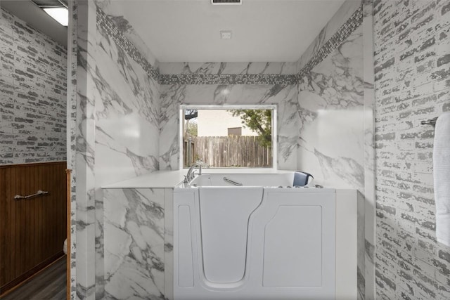 2821 Creek Side Dr, Temple, TX 76502 - bathroom with wallpapered walls, a bath, and wainscoting