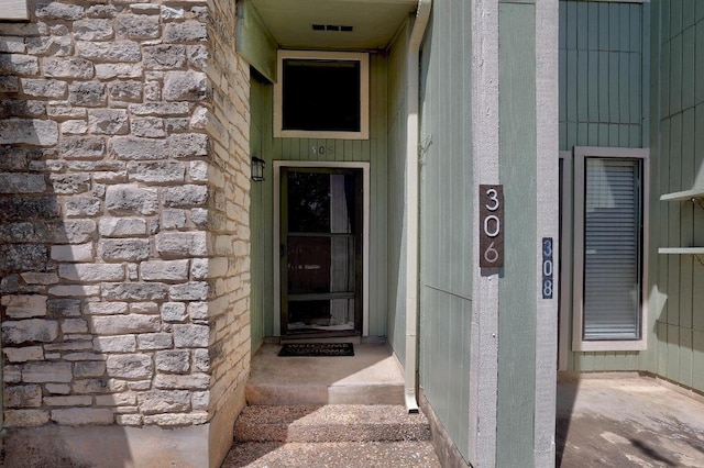 property entrance featuring stone siding