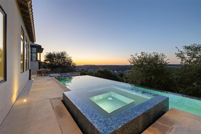 308 Duckhorn Pass, Austin, TX 78738 - pool at dusk featuring an in-ground hot tub, a patio area, and an outdoor pool