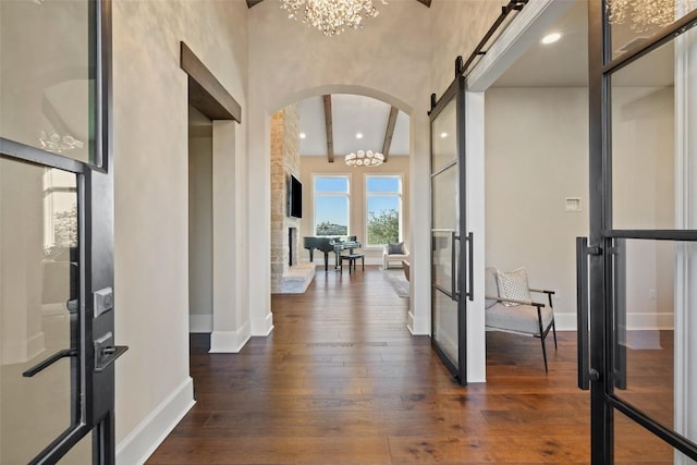 308 Duckhorn Pass, Austin, TX 78738 - foyer featuring arched walkways, a chandelier, dark wood-type flooring, and baseboards