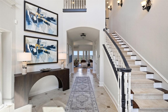 1071 Escalar Dr, Buchanan Dam, TX 78609 - tiled foyer featuring stairs, a towering ceiling, arched walkways, and baseboards