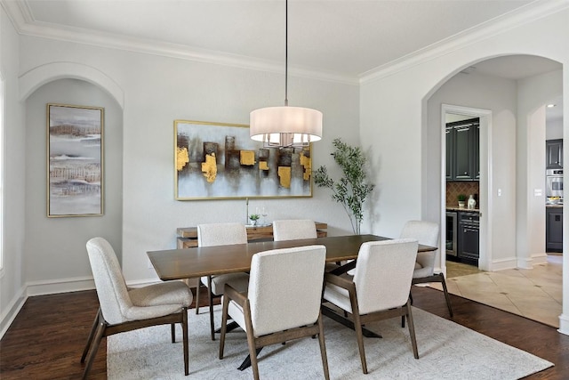1071 Escalar Dr, Buchanan Dam, TX 78609 - dining room featuring arched walkways, crown molding, beverage cooler, baseboards, and light wood-style floors