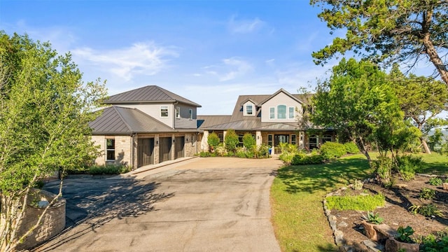 1071 Escalar Dr, Buchanan Dam, TX 78609 - view of front of house featuring concrete driveway, a porch, metal roof, a standing seam roof, and a garage