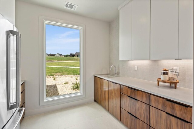 298 Glenview Cir, Belton, TX 76513 - kitchen featuring high end refrigerator, a sink, tasteful backsplash, light countertops, and modern cabinets