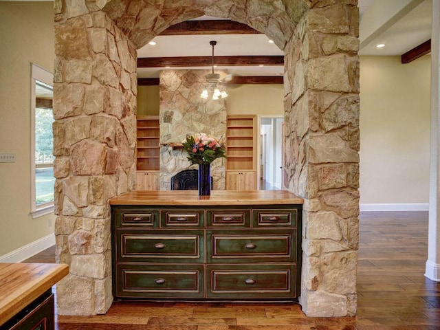 123 County Rd, Paige, TX 78659 - detailed view of arched walkways, beam ceiling, baseboards, wood finished floors, and a ceiling fan