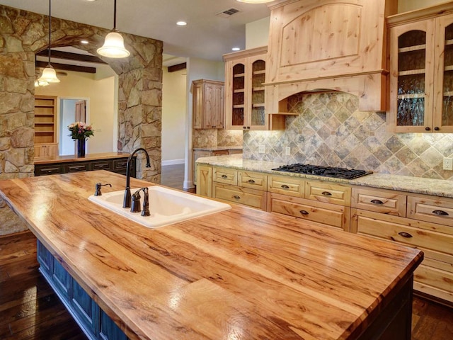 123 County Rd, Paige, TX 78659 - kitchen with wooden counters, a sink, black gas cooktop, dark wood-style floors, and backsplash