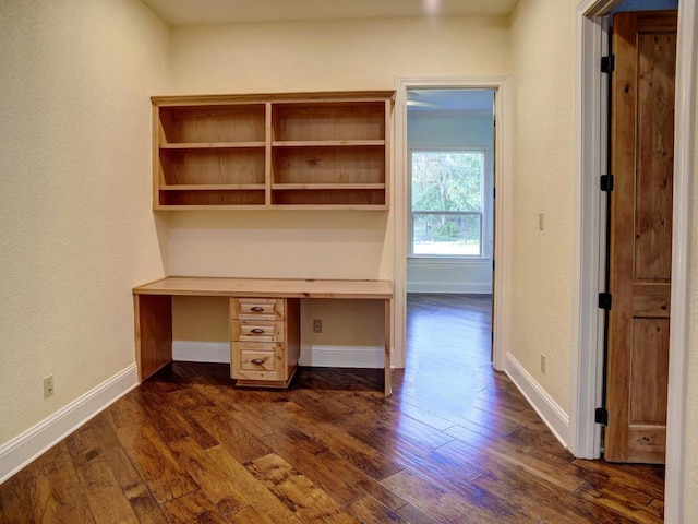 123 County Rd, Paige, TX 78659 - unfurnished office featuring dark wood-style floors, built in desk, and baseboards