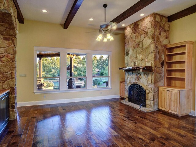 123 County Rd, Paige, TX 78659 - unfurnished living room with a fireplace, a ceiling fan, beamed ceiling, dark wood-type flooring, and healthy amount of natural light