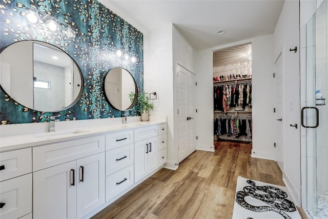 8603 Big Horn Cir, Lago Vista, TX 78645 - bathroom with wood finished floors, double vanity, a shower stall, a spacious closet, and recessed lighting