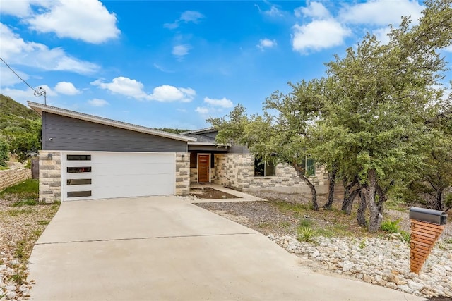 8603 Big Horn Cir, Lago Vista, TX 78645 - contemporary house featuring stone siding, a garage, and concrete driveway