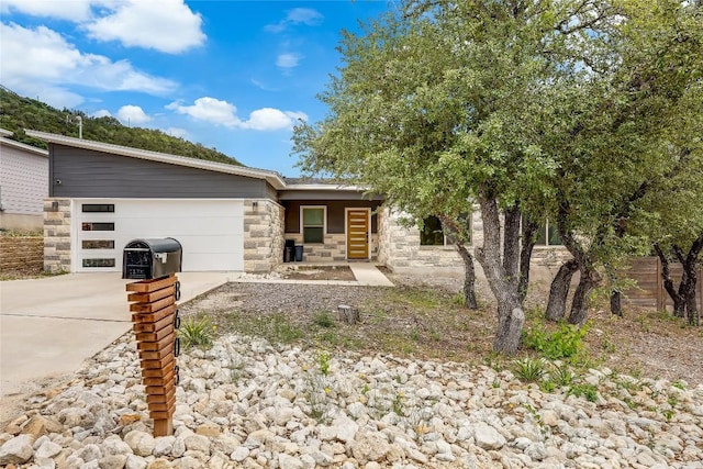8603 Big Horn Cir, Lago Vista, TX 78645 - view of front of house with stone siding, an attached garage, and driveway