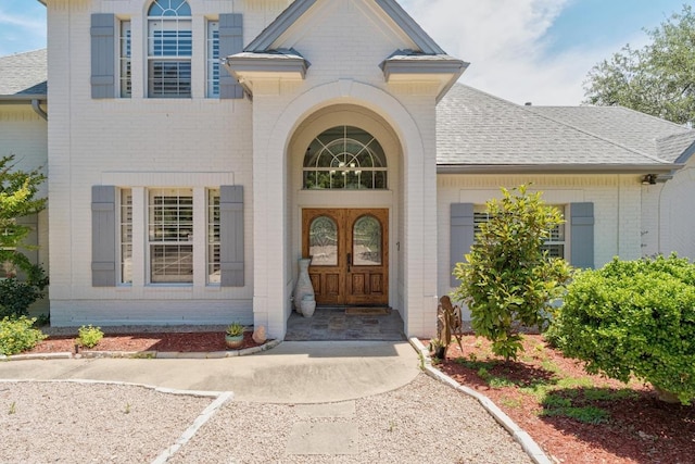 9201 Silver Pine Cv, Austin, TX 78733 - view of exterior entry with brick siding and roof with shingles