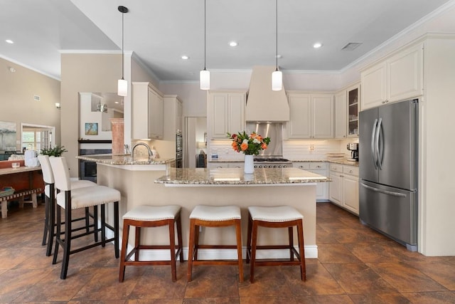 9201 Silver Pine Cv, Austin, TX 78733 - kitchen featuring freestanding refrigerator, a peninsula, crown molding, custom range hood, and light stone countertops