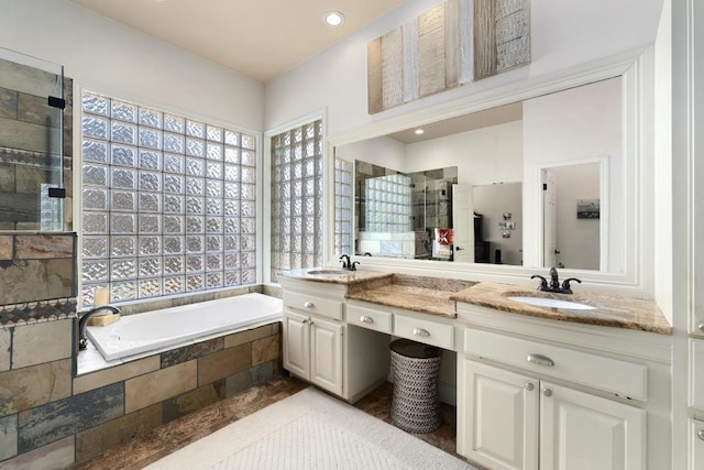 9201 Silver Pine Cv, Austin, TX 78733 - bathroom featuring a stall shower, plenty of natural light, a garden tub, double vanity, and recessed lighting
