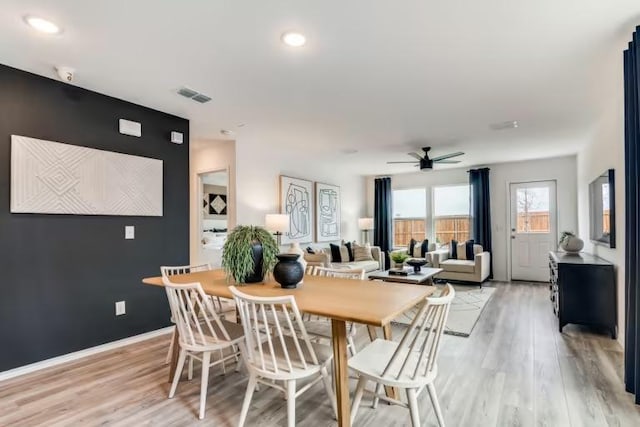 dining area with a ceiling fan, light wood-style floors, and baseboards