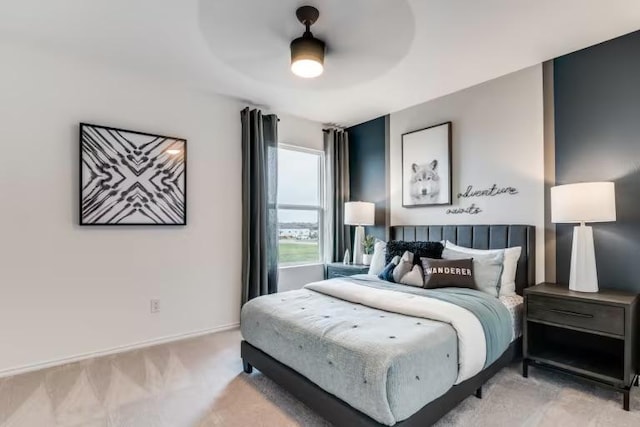 bedroom featuring light carpet, ceiling fan, and baseboards