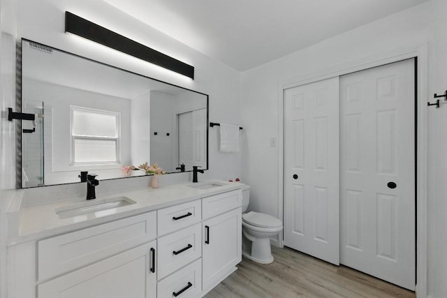 8805 Ravello Pass, Austin, TX 78749 - bathroom with double vanity, toilet, and wood finished floors