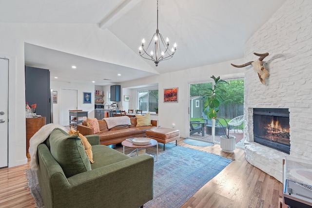 living area with a chandelier, a fireplace, beam ceiling, high vaulted ceiling, and light wood-style floors