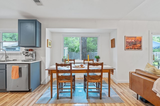 dining space with light wood-type flooring, plenty of natural light, and baseboards