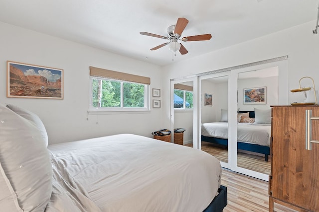 bedroom featuring light wood-type flooring, ceiling fan, and a closet