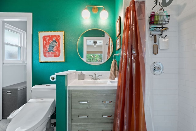 full bath featuring vanity, toilet, tiled shower, and a ceiling fan