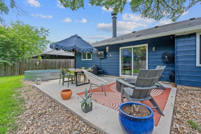 view of patio / terrace featuring fence, a hot tub, and outdoor dining area