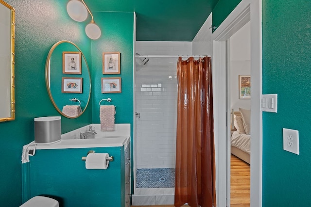 2612 Baxter Dr, Austin, TX 78745 - ensuite bathroom with vanity, a tile shower, a textured wall, and toilet