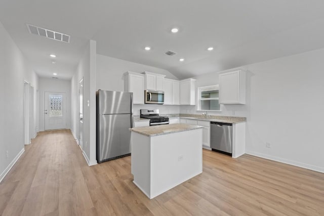 464 Aplite Pass, Maxwell, TX 78656 - kitchen with appliances with stainless steel finishes, white cabinetry, a kitchen island, light wood-style flooring, and baseboards
