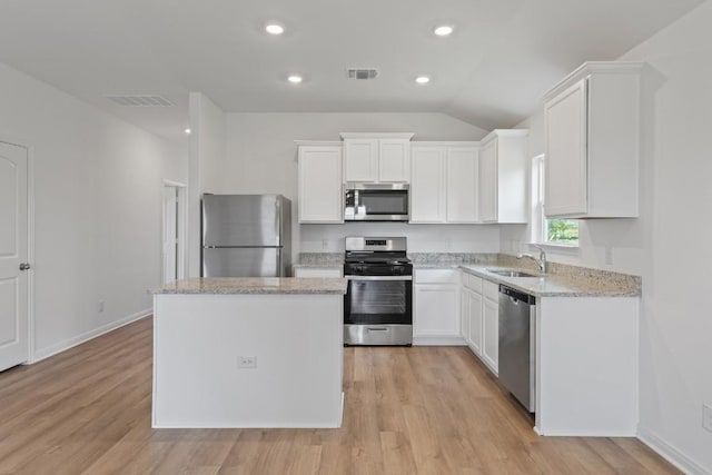464 Aplite Pass, Maxwell, TX 78656 - kitchen with stainless steel appliances, a sink, a kitchen island, white cabinets, and lofted ceiling
