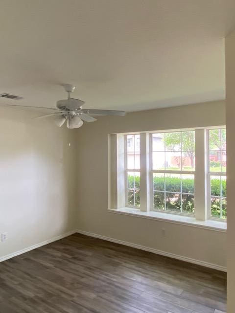 unfurnished room with baseboards, wood finished floors, and ceiling fan