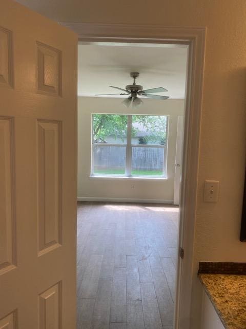 empty room with ceiling fan and wood finished floors