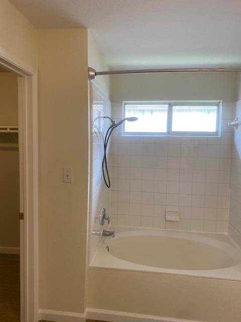 bathroom with baseboards and shower / washtub combination