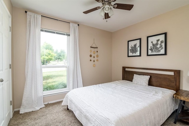 bedroom featuring multiple windows, carpet, baseboards, and a ceiling fan