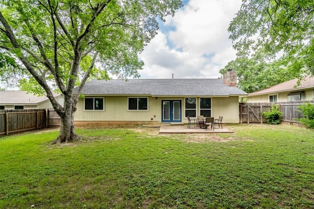 rear view of house featuring french doors, a chimney, a patio area, and roof with shingles