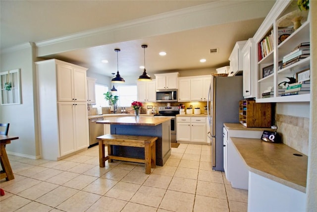 2502 Joseph Dr, Copperas Cove, TX 76522 - kitchen with appliances with stainless steel finishes, a kitchen island, backsplash, white cabinets, and crown molding