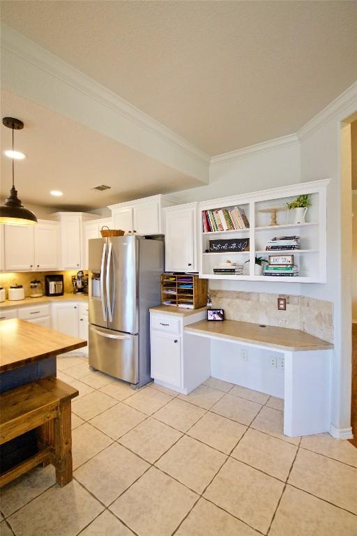 2502 Joseph Dr, Copperas Cove, TX 76522 - kitchen with stainless steel refrigerator with ice dispenser, crown molding, light countertops, white cabinets, and light tile patterned flooring