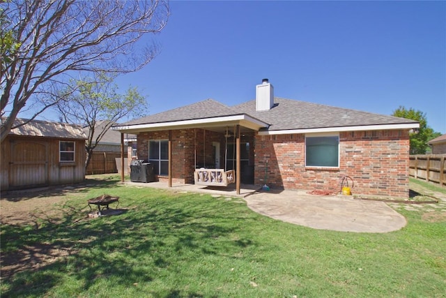 2502 Joseph Dr, Copperas Cove, TX 76522 - rear view of house with a fire pit, a chimney, brick siding, a patio area, and an outbuilding