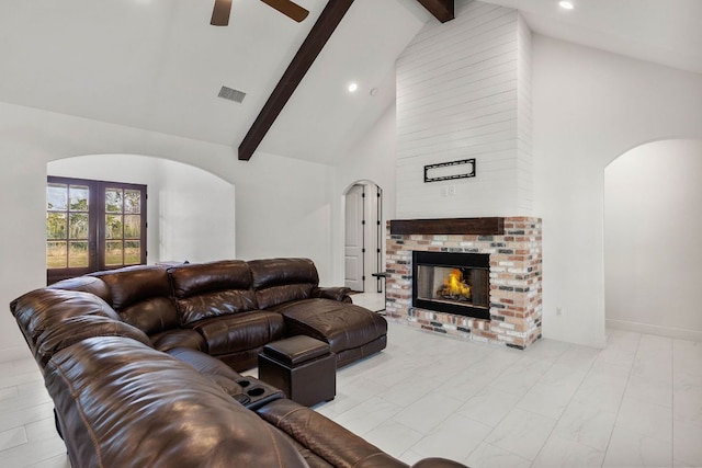 479 Brown Rd, Mcdade, TX 78650 - living area featuring arched walkways, a ceiling fan, high vaulted ceiling, beamed ceiling, and a fireplace