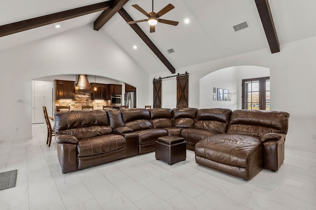 479 Brown Rd, Mcdade, TX 78650 - living room with arched walkways, a barn door, beam ceiling, a ceiling fan, and high vaulted ceiling